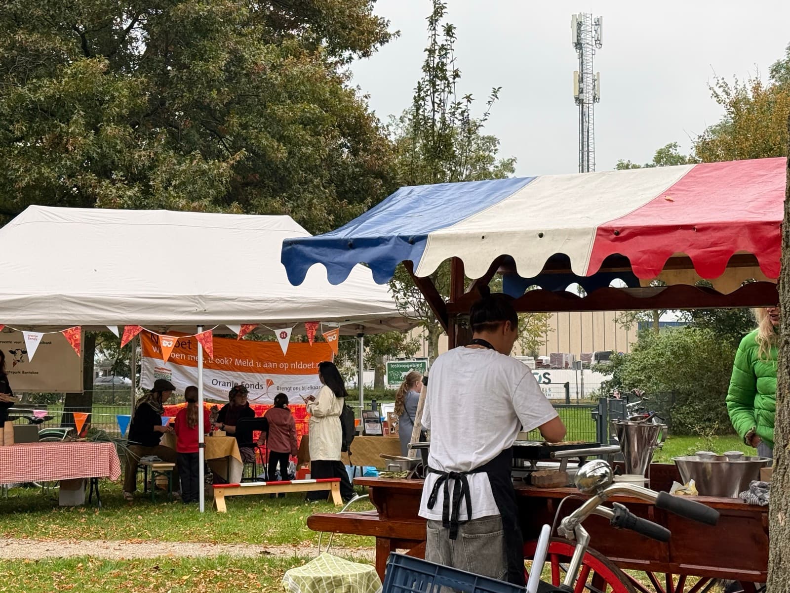 Bezoekers halen verse poffertjes bij de Poffertjesland-kraam op een festival